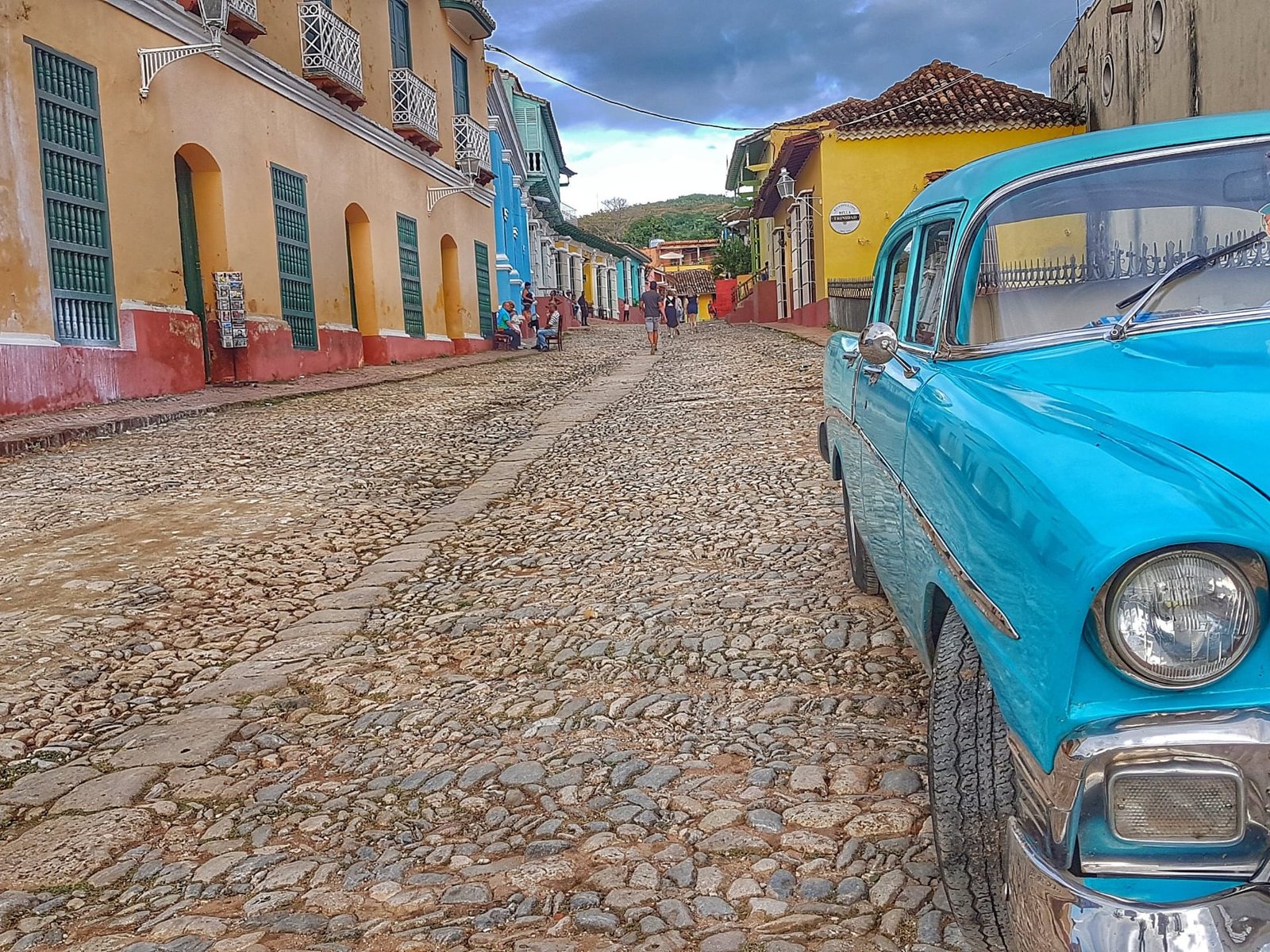 Un’auto d’epoca turchese in una strada acciottolata di Trinidad, fra le case colorate