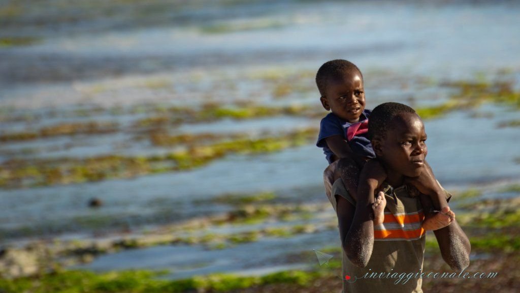 Bambini locali sulla battigia, tra le pozze di marea