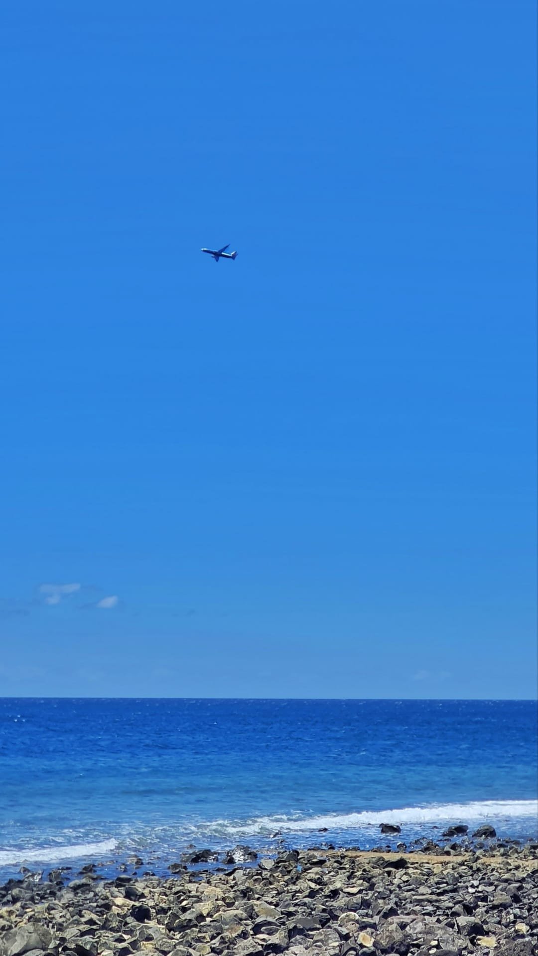 I ciottoli neri a contrasto con il mare azzurro